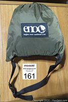 Tarp folded inside olive green stuff sack with black carry strap and ENO logo patch.