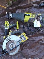 Photo showing three Ryobi tools: circular saw with rusted blade, corded reciprocating saw (Sawzall), and cordless drill without battery or charger.