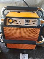 Photo of ION Job Rocker portable Bluetooth speaker showing top control panel with volume knob, radio controls, and power switch. Bright orange speaker grills and chrome frame with handle visible.