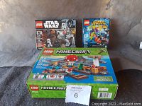 Photo of all three LEGO sets in original packaging: Star Wars, DC Super Heroes, and Minecraft.