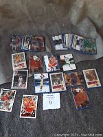 Photo showing multiple basketball cards spread out having action shots of various NBA players including Michael Jordan and others.