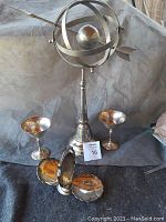 Full view showing armillary sphere on tall stand, two silver goblet cups behind it, and a vintage divided mint dish in front.