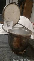 Silver ice bucket open showing interior and hinged lid