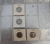 Four Buffalo nickels in individual white coin holders with clear plastic, two from 1935 and two from 1936, each marked with 'E'.