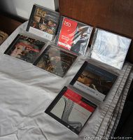 Seven Toronto Symphony Orchestra annual CDs displayed on a white cloth surface, each still sealed in plastic wrap, labeled with various years and featuring orchestra-related cover art.