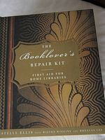 Closed book-shaped box titled 'The Booklover's Repair Kit First Aid for Home Libraries' with decorative patterned cover.