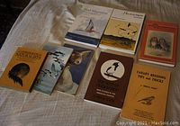 All eight books laid out on a white fabric background showing covers: titles and bird images visible for identification