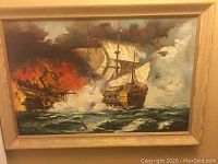 Overall front view of oil painting in wooden frame depicting naval battle