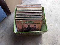 Box of approximately 50 vintage LP records with 'Elvis - The Greatest Show on Earth' album visible on top