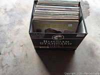 Box containing approximately 50 vintage vinyl record LPs with visible album covers including Elvis Costello.