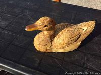 Full side view of wooden duck decoy showing overall shape and paint.
