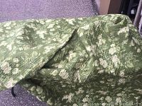 Photo showing the green floral quilt draped on a surface highlighting the overall pattern and texture.