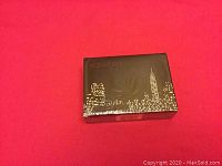 Photo of a black box with gold city skyline and 'SEX AND THE CITY' text on a red background.
