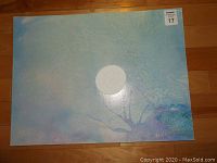Front view of the abstract painting with blue gradient background and central circular shape, artist signature visible.
