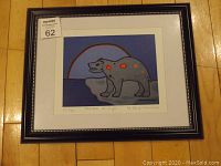Framed fine art print on wooden floor, visible frame and white mat.