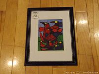 Full framed print lying flat on a wooden floor showing overall appearance and frame style.