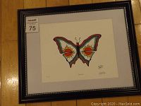 Full view of newly framed fine art print titled 'Two Suns' featuring a colorful butterfly with sun motifs, inside a dark wood frame.