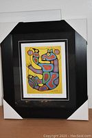 Full view of framed artwork with protective corners showing the print 'Medicine Bear with Helper' by Norval Morrisseau
