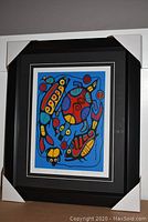 Framed art print with black mat borders and white inner mat, corners protected by cardboard corner guards.