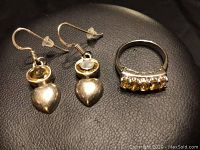 Photo of the sterling silver earrings and matching ring placed on a black surface.