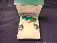 Pair of teardrop earrings with green Connemara marble set in sterling silver in box with green tag.