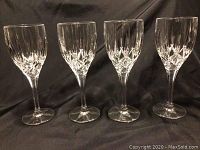 Front view of four crystal Royal Doulton wine glasses lined up showing cut crystal pattern detail.