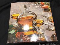 Closed color-printed box showing Luigi Bormioli Napoleon Cognac set with decanter and four glasses full of cognac liquid on front.