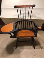Miniature Windsor chair with comb-back spindles and attached writing arm, wood finish in black and natural tones, photographed from a side angle to show structure and design.