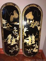 Front view of the two black lacquer panels side by side showing full detailed mother of pearl inlays and gold accents.