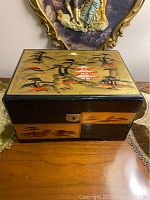 Front and angled view showing box construction with drawers and side handle, and visible wear on exterior paint.