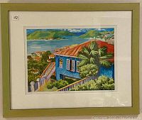 Full view of framed limited edition print depicting a vibrant tropical landscape with a blue house and red roof, numbered 112.