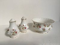 Three-piece set of Royal Albert Winsome bone china salt and pepper shakers with sugar bowl decorated with floral pattern and gold trim.