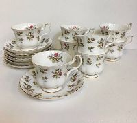 Full set of 8 teacups and 8 saucers arranged with close-up views of the cup handle, floral pattern, and gold trim