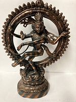 Full view of the large metal East Indian sculpture showing the dynamic dancing figure within the circular flame motif frame on a round base.