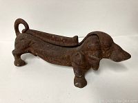 Full side view of the cast iron dachshund boot scraper showing elongated body, detailed head, and curled tail.