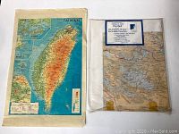 Photo of the Taiwan map showing the full island with elevations and geographic details alongside a large China map sealed in plastic.