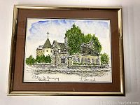 Framed watercolor and ink piece showing Chateau De Ramizay, Montreal building with a turret and gate pillars, signed L. Leonard, overall view of the artwork and frame.