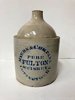 Front view of the whiskey crock jug showing circular blue stenciled text.