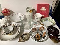 Overview of lot showing various dishes, cups, bowls, glassware, and decorative items.