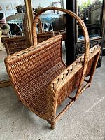 Side angled view of wicker magazine rack showing detailed woven pattern and structure.