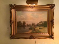 Full view of framed oil painting with overhead light fixture