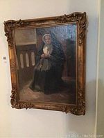 Full view of the framed oil painting showing nun and frame