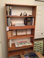 Full front view of teak bookcase with books and decorative items on shelves (not included).