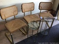 Three cane chairs and two brass glass plant stands overview