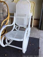 White bentwood rocking chair with cane seat and backrest, showing front and side angles and detail of woven cane.