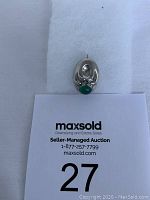 Top view of the antique silver brooch with visible green chrysoprase cabochon stone.