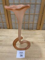 Front view of the pink frosted glass trumpet shaped vase showing the coiled base and flared top.