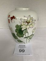 Front side of Japanese porcelain vase showing lotus flower and butterfly artwork.