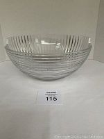 Front and side view of heavy crystal bowl featuring vertical ridges and uneven edge, showing clear condition with no chips or cracks.