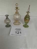 Front view of all three perfume bottles showing shape, color, and stopper details